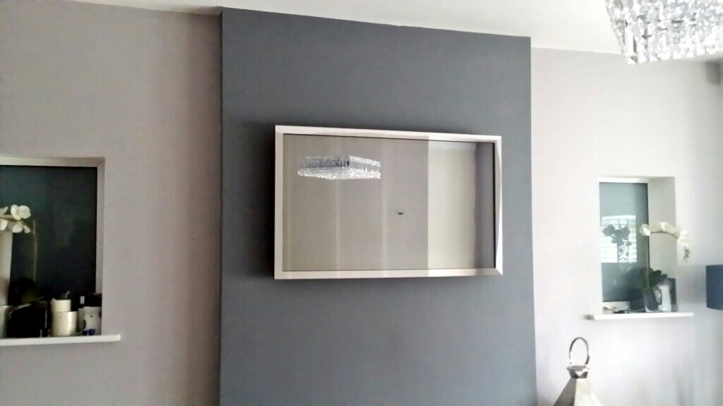 The same Mirror TV switched off, appearing as a framed mirror on the wall