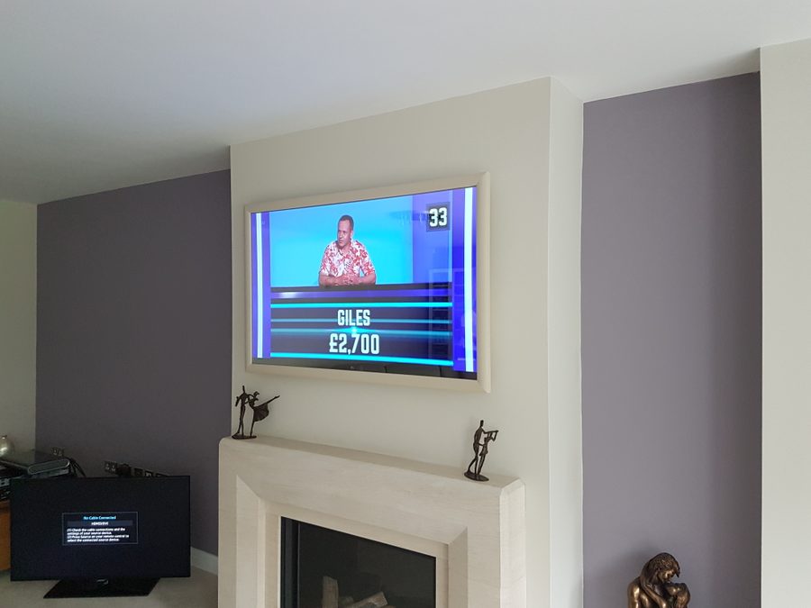Bronze-framed Mirror TV above a black and white marble fireplace in a contemporary room